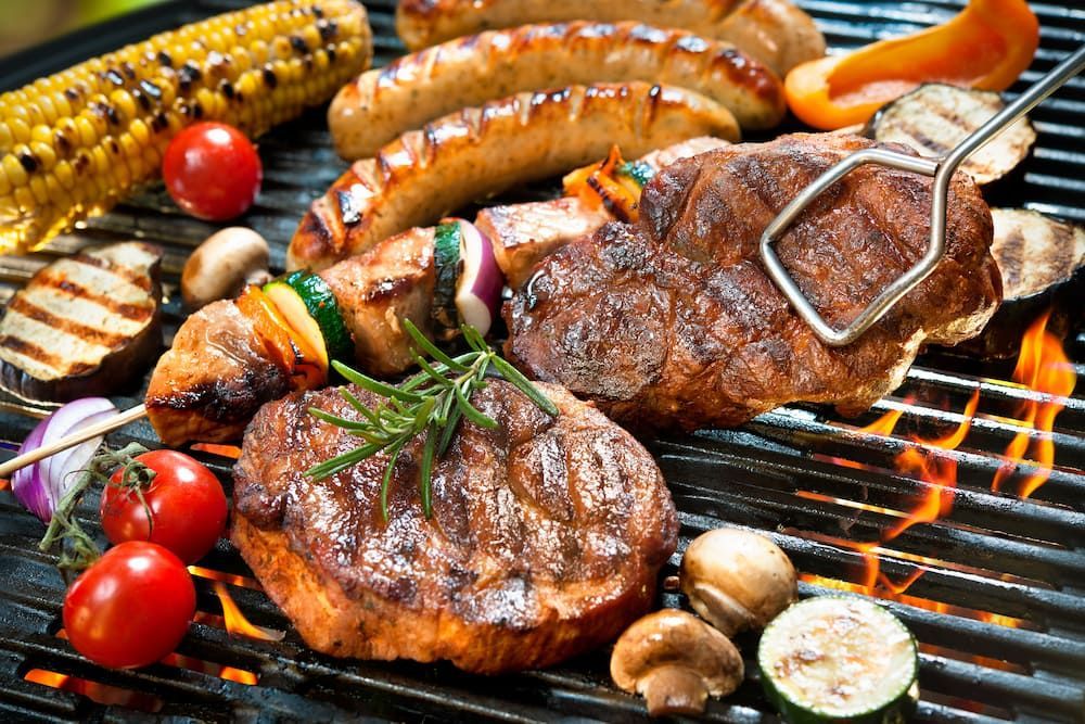 A Variety Of Meats And Vegetables Are Cooking On A Grill — Wattle Butchery In Cootamundra, NSW