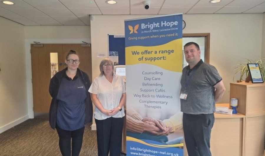 Three people stand by a 