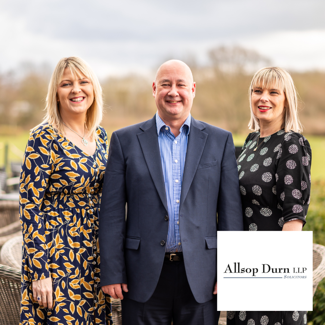 Accessible bathroom with shower, toilet, and grab bars. Gray walls and dark fixtures.
