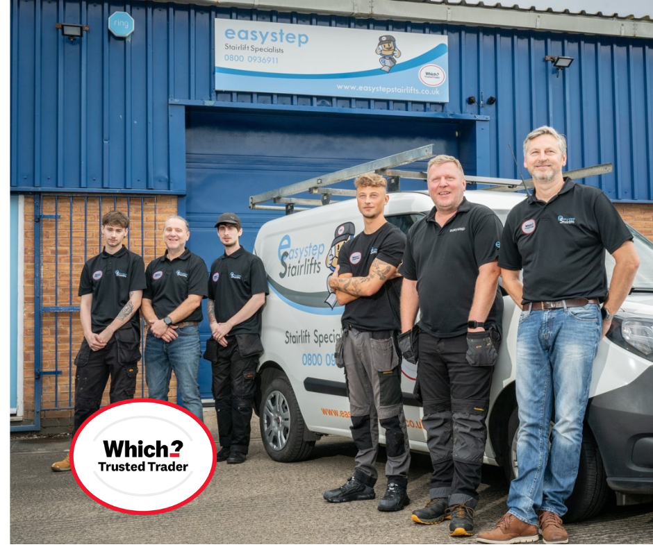 Accessible bathroom with shower, toilet, and grab bars. Gray walls and dark fixtures.