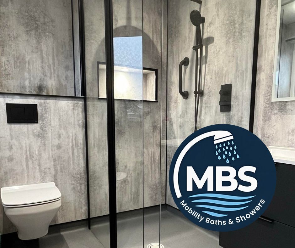 Accessible bathroom with shower, toilet, and grab bars. Gray walls and dark fixtures.