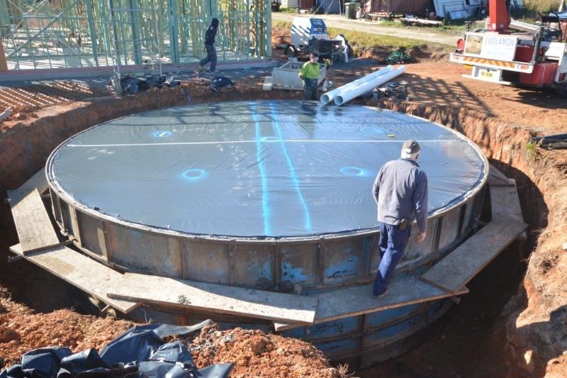 Person Standing on a Round Metal Tank — Coffs Harbour, NSW — Coolamon Concrete Tanks