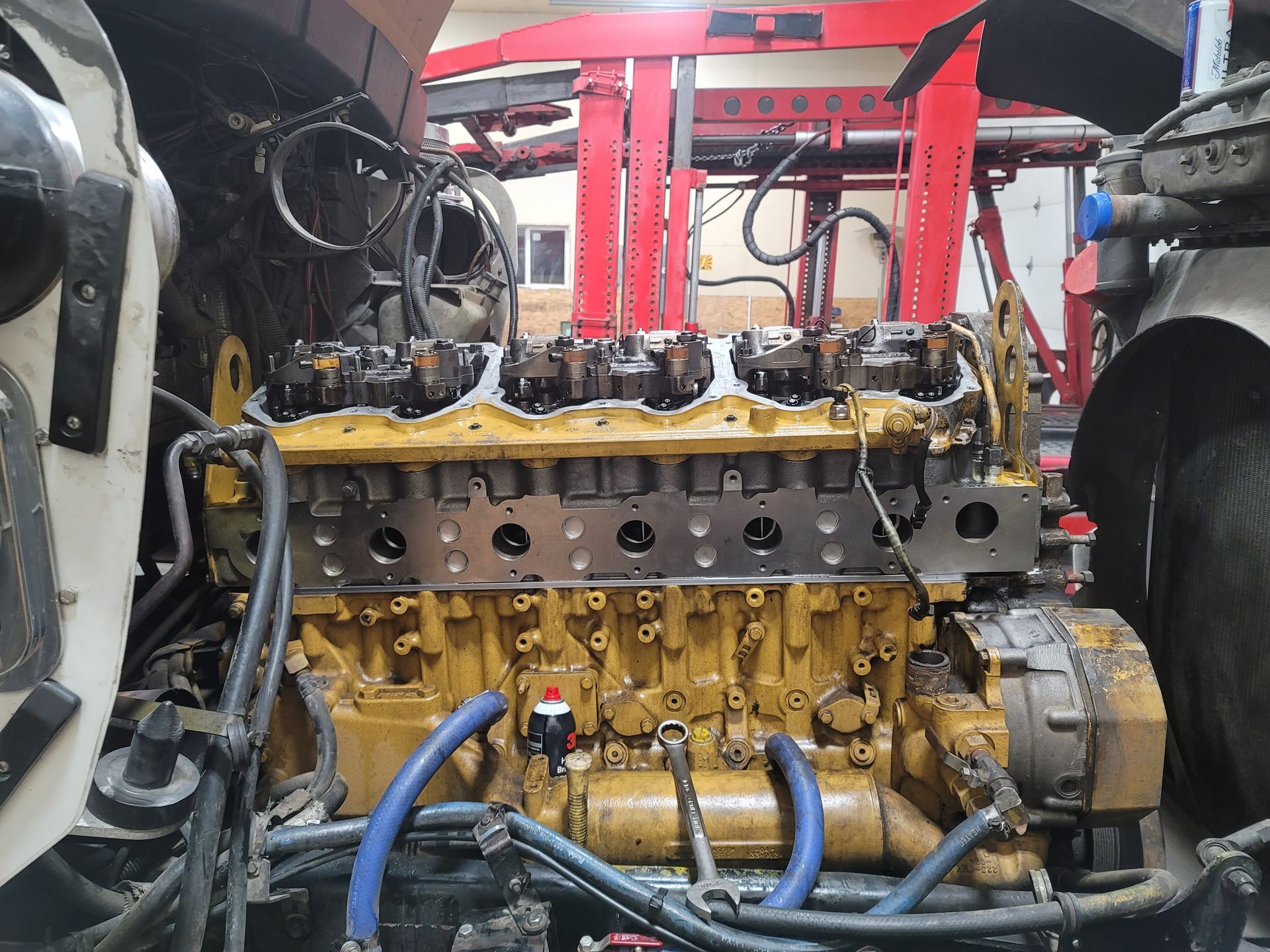 The engine of a truck is being repaired in a garage.
