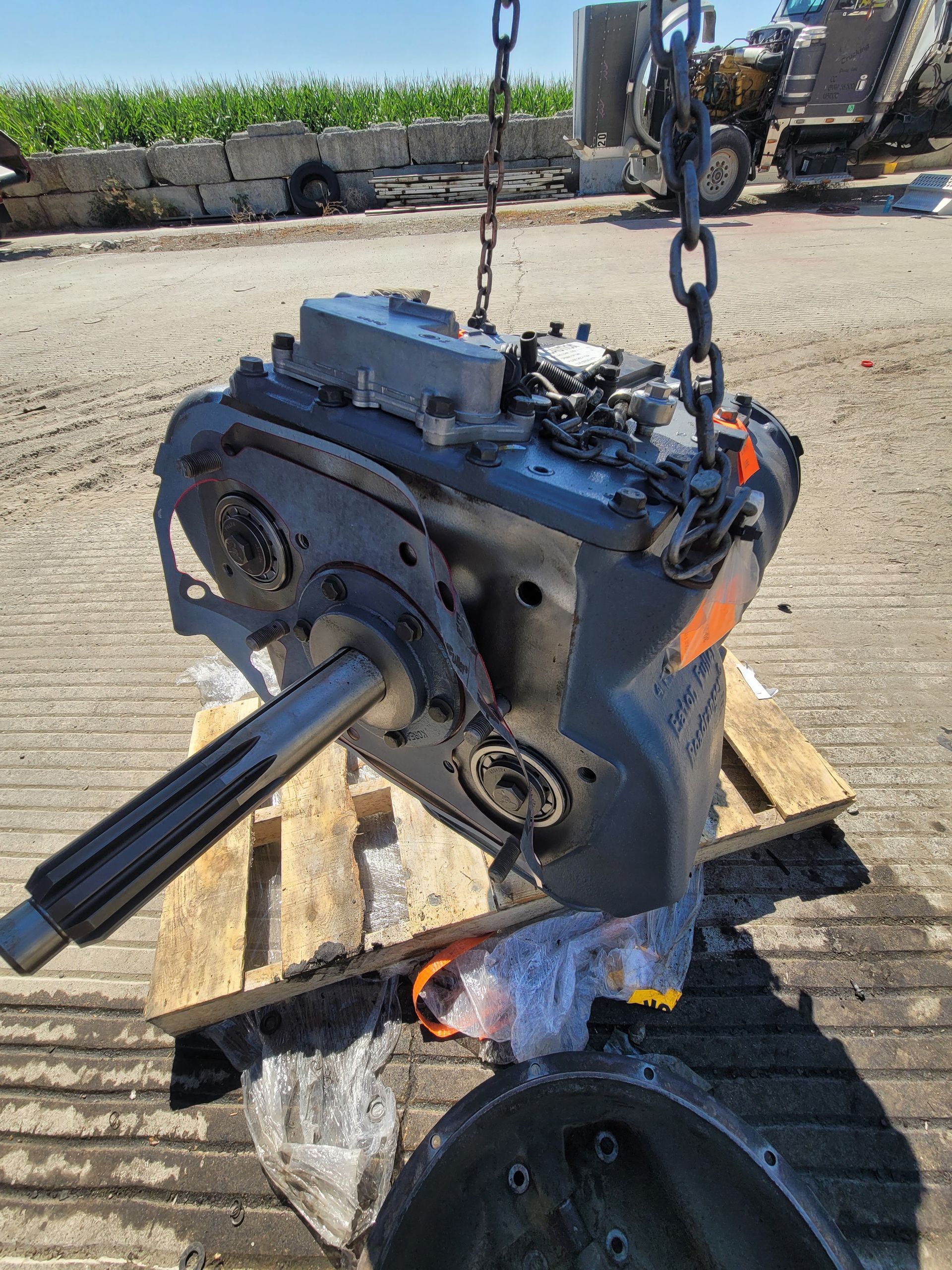 A large engine is sitting on top of a wooden pallet.