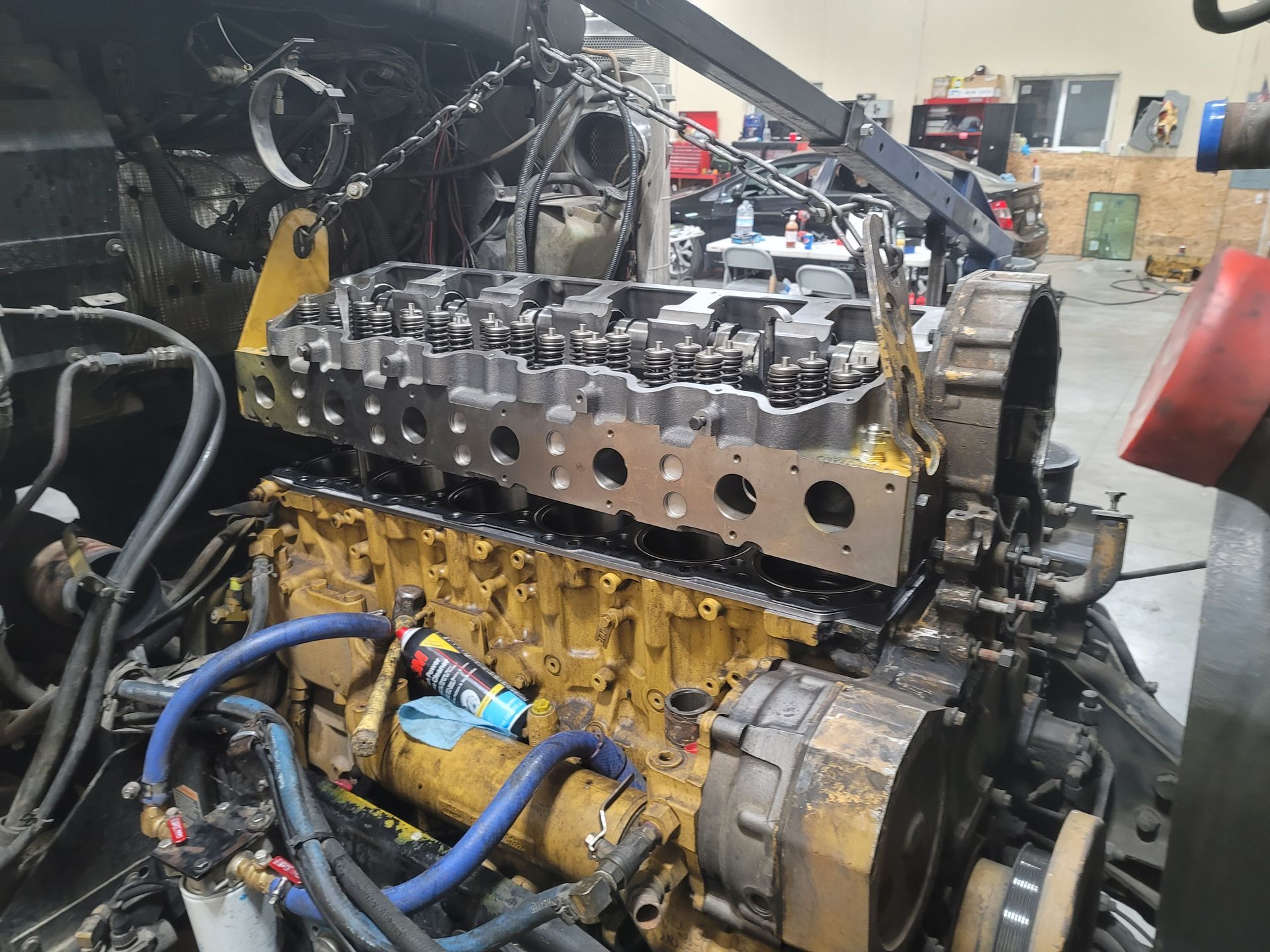 The engine of a truck is being repaired in a garage.