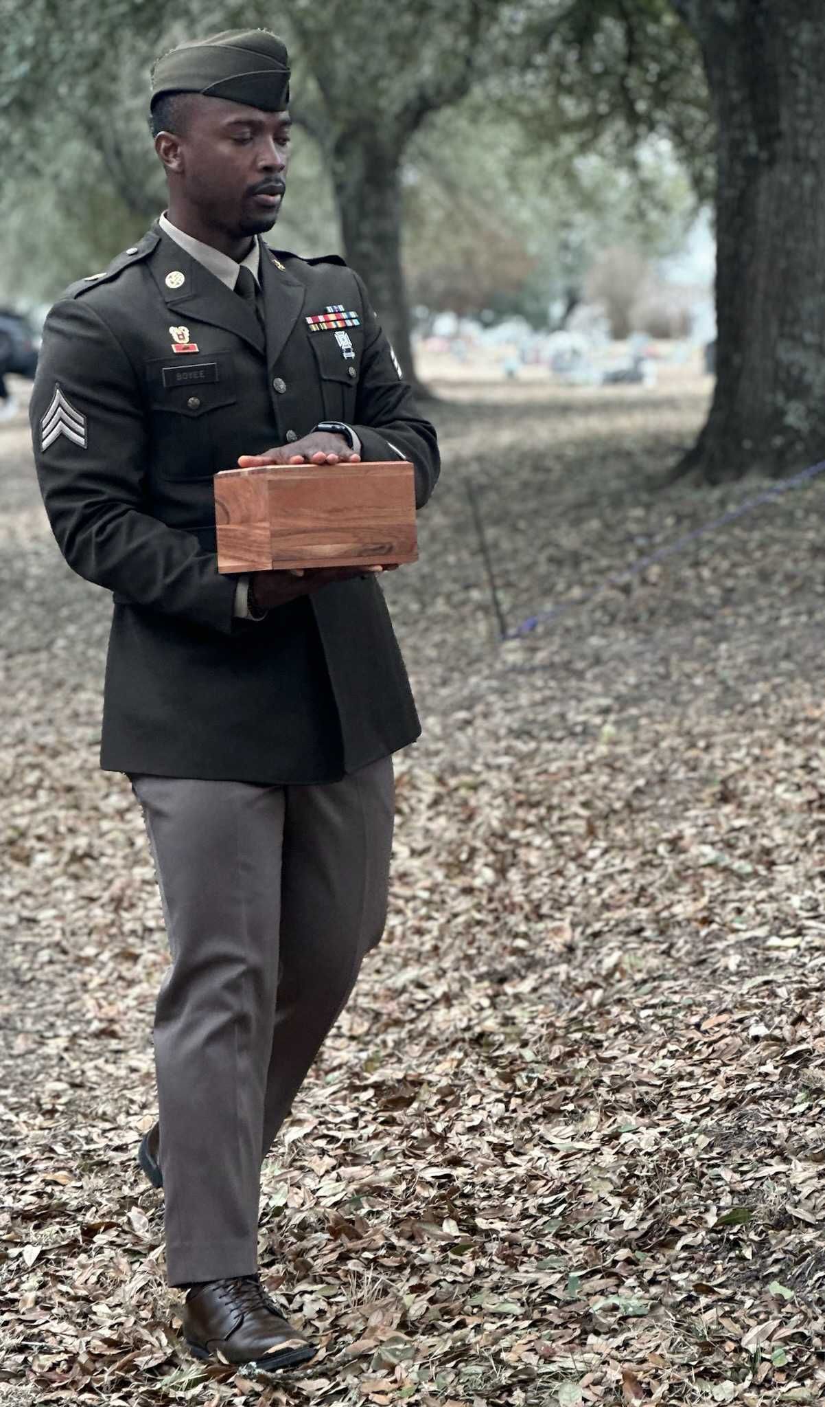 A woman is putting her hand on an American flag at a funeral.