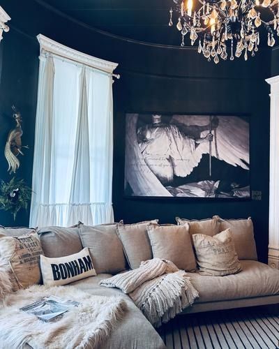 Cozy living room with dark blue walls, light-colored sofa, and large black and white artwork.