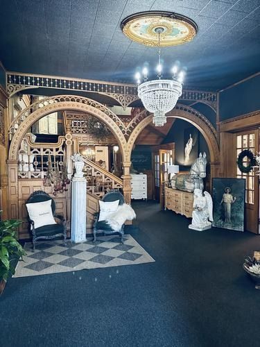 Ornate interior with decorative wooden arches, crystal chandelier, and antique furnishings.