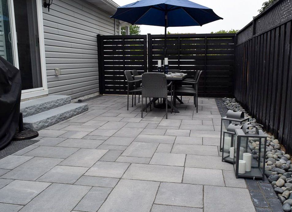A patio with a table and chairs under an umbrella