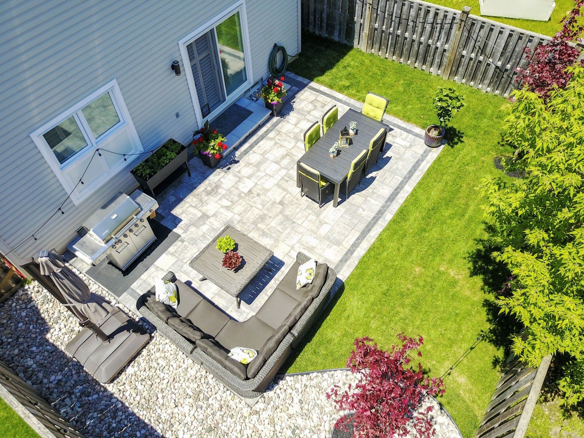 An aerial view of a backyard with a patio and a table and chairs.