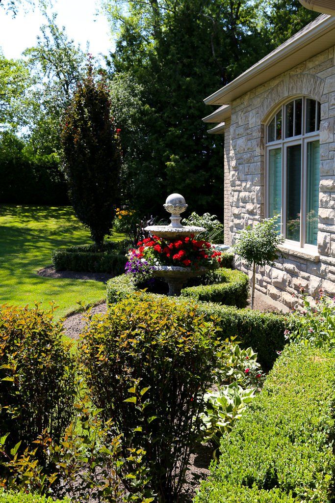 A stone house with a fountain in front of it