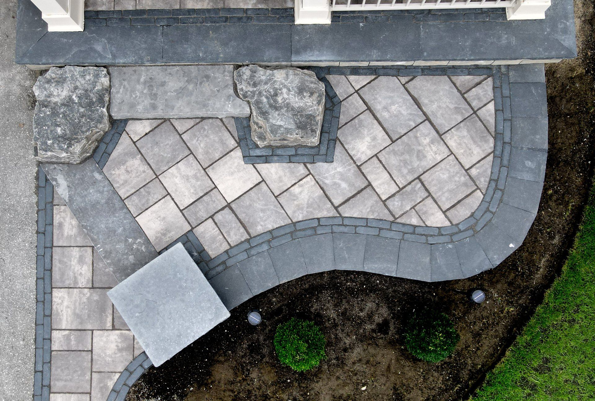 An aerial view of a patio being built in front of a house.