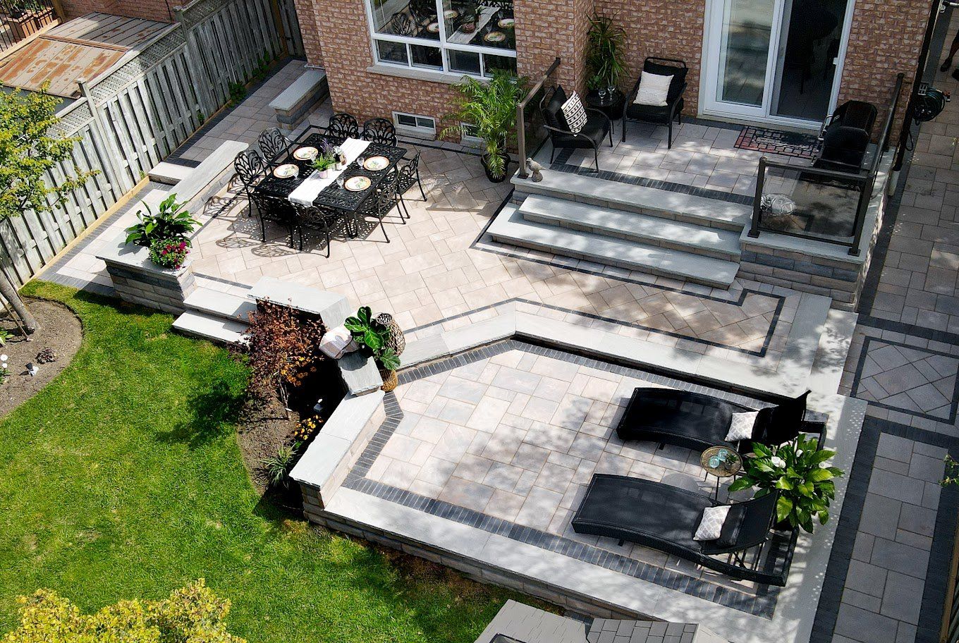 An aerial view of a patio with a table and chairs in the backyard of a house.