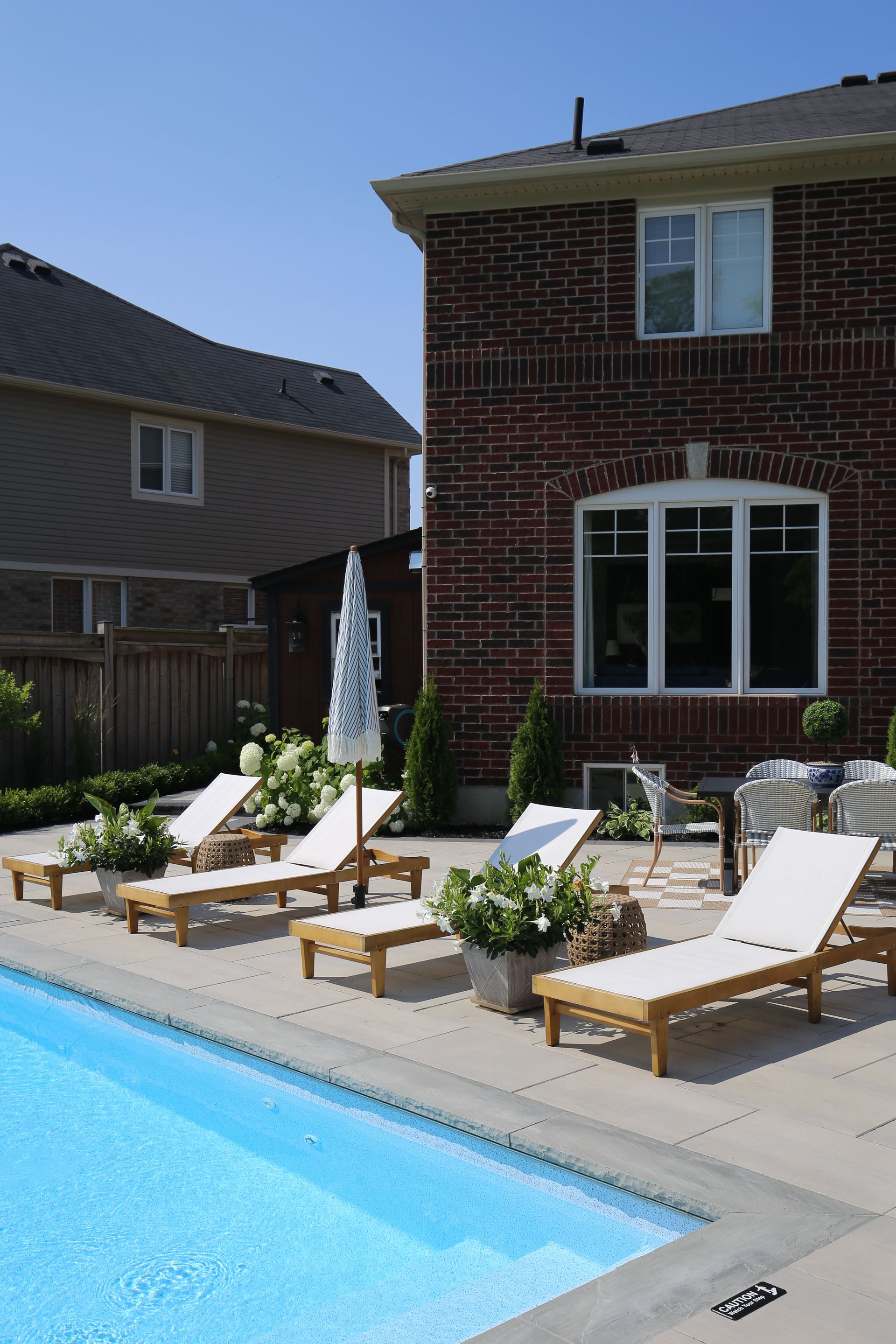 A brick house with a swimming pool in front of it