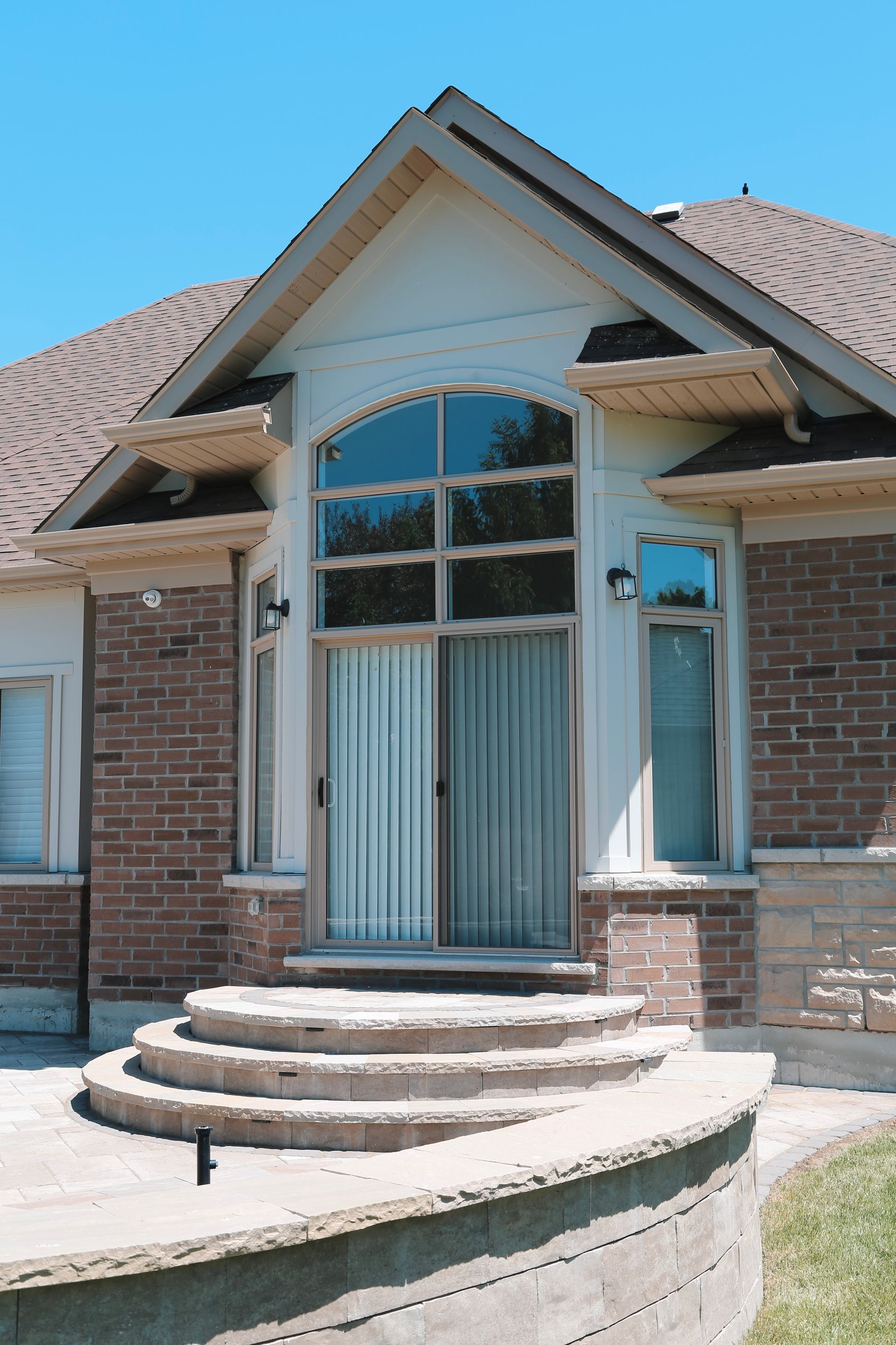 A brick house with stairs leading up to the front door