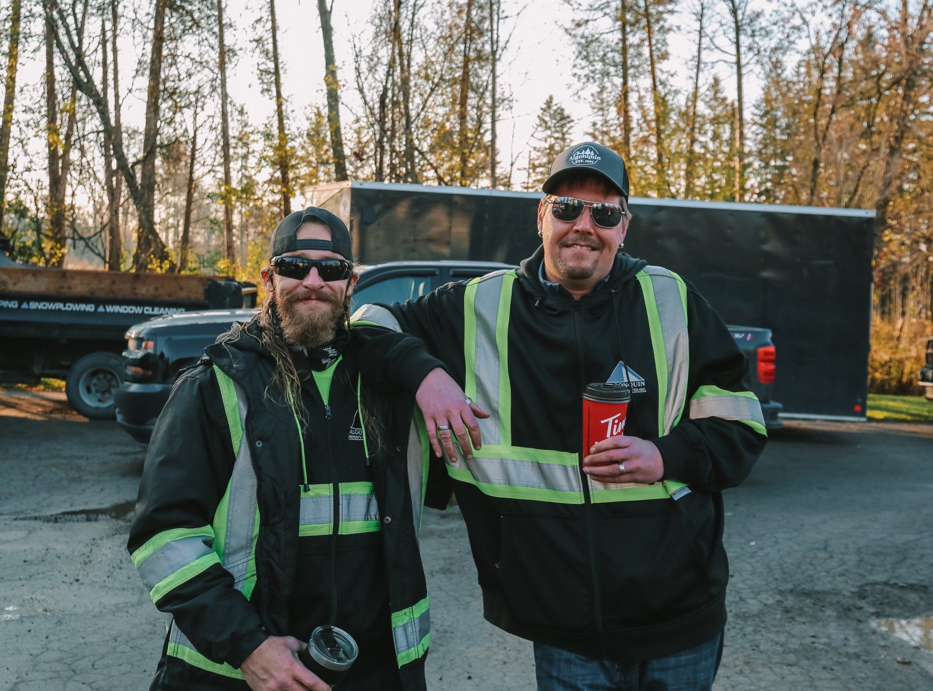 Two men are standing next to each other in a parking lot.