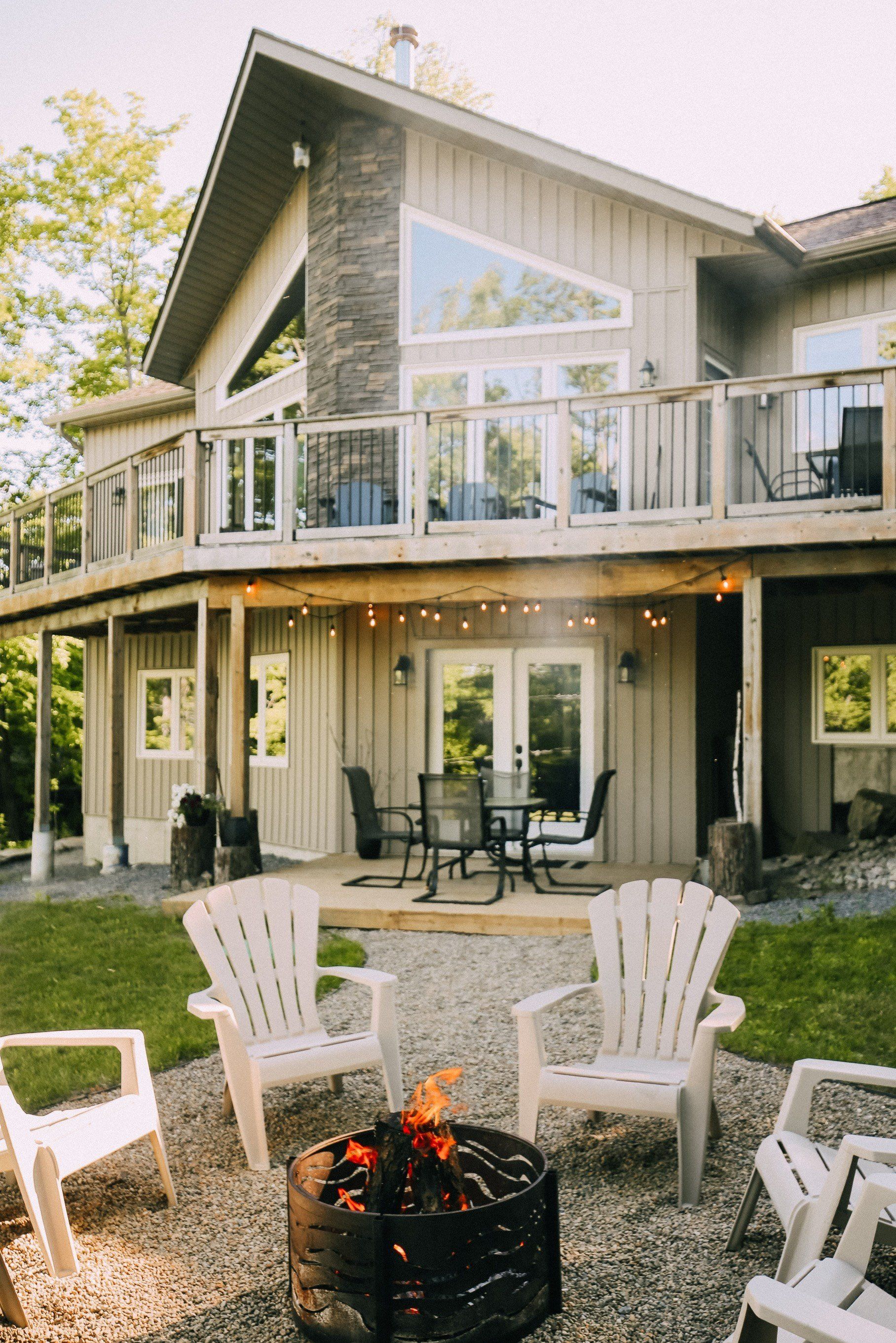 There is a fire pit in front of a large house.