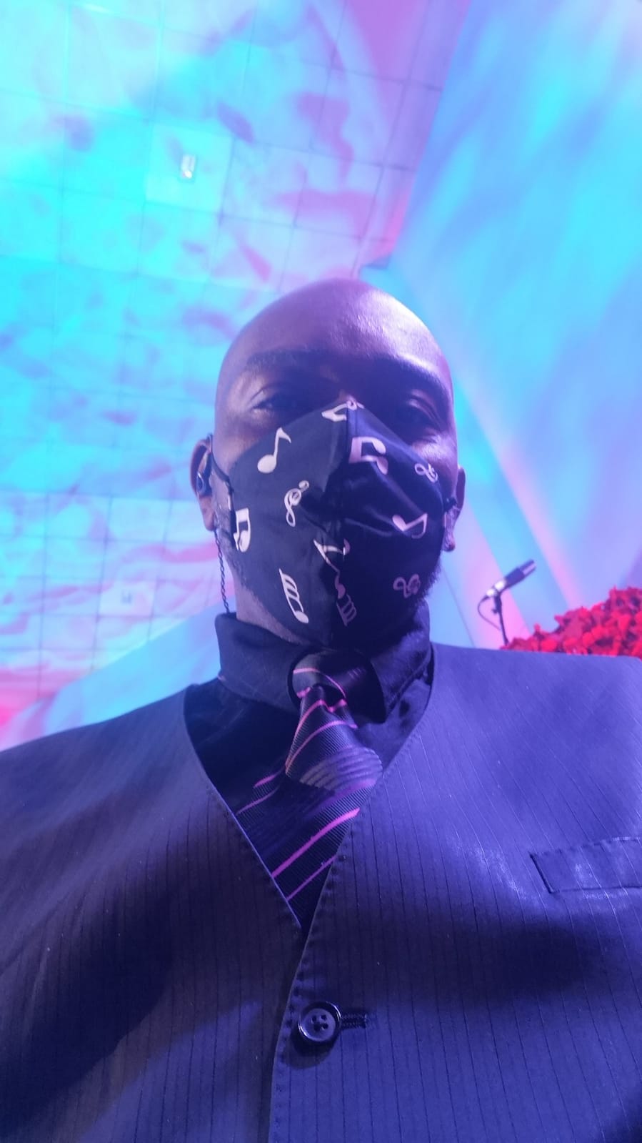 A man in a suit and tie is wearing a face mask.