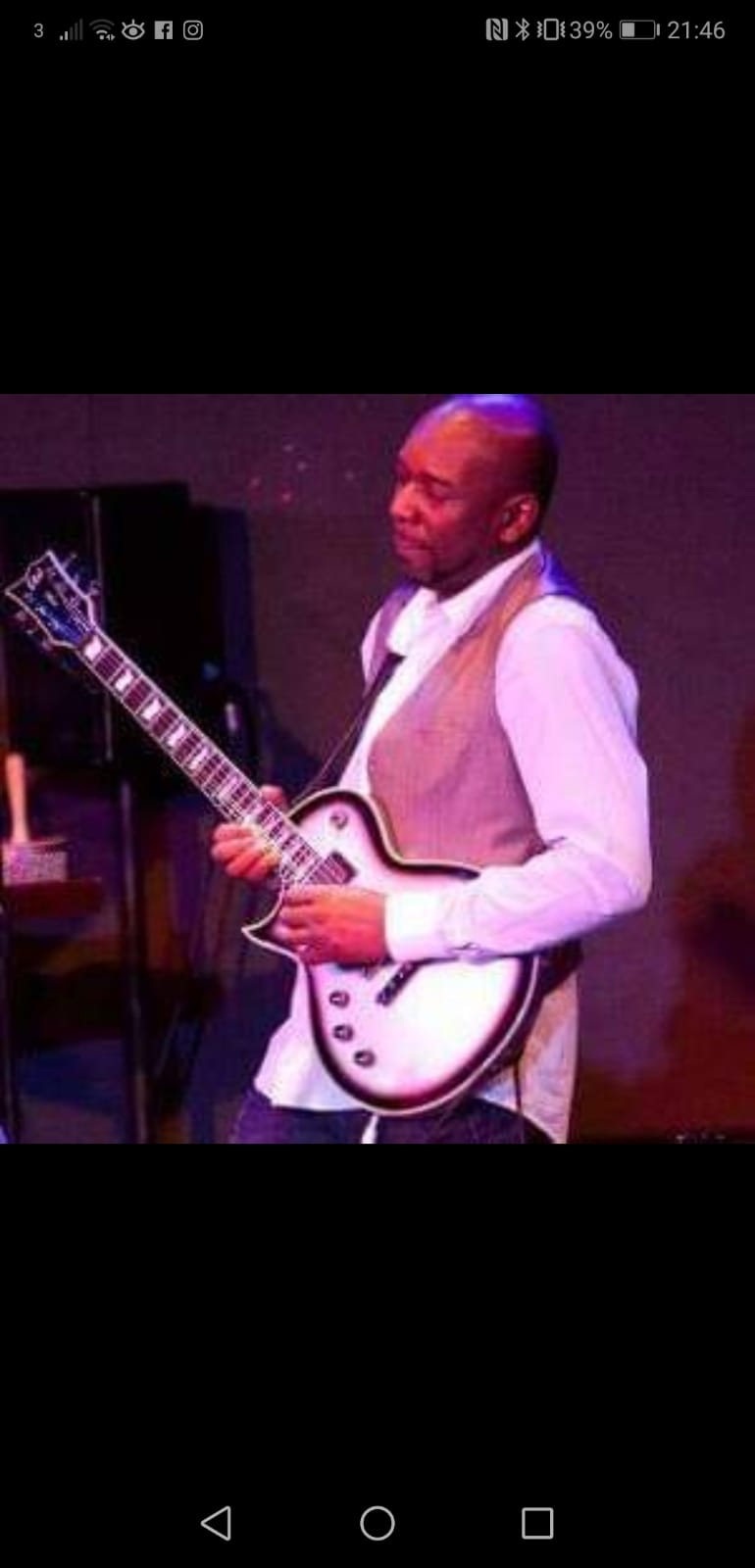 Ollie P playing a guitar on a stage.