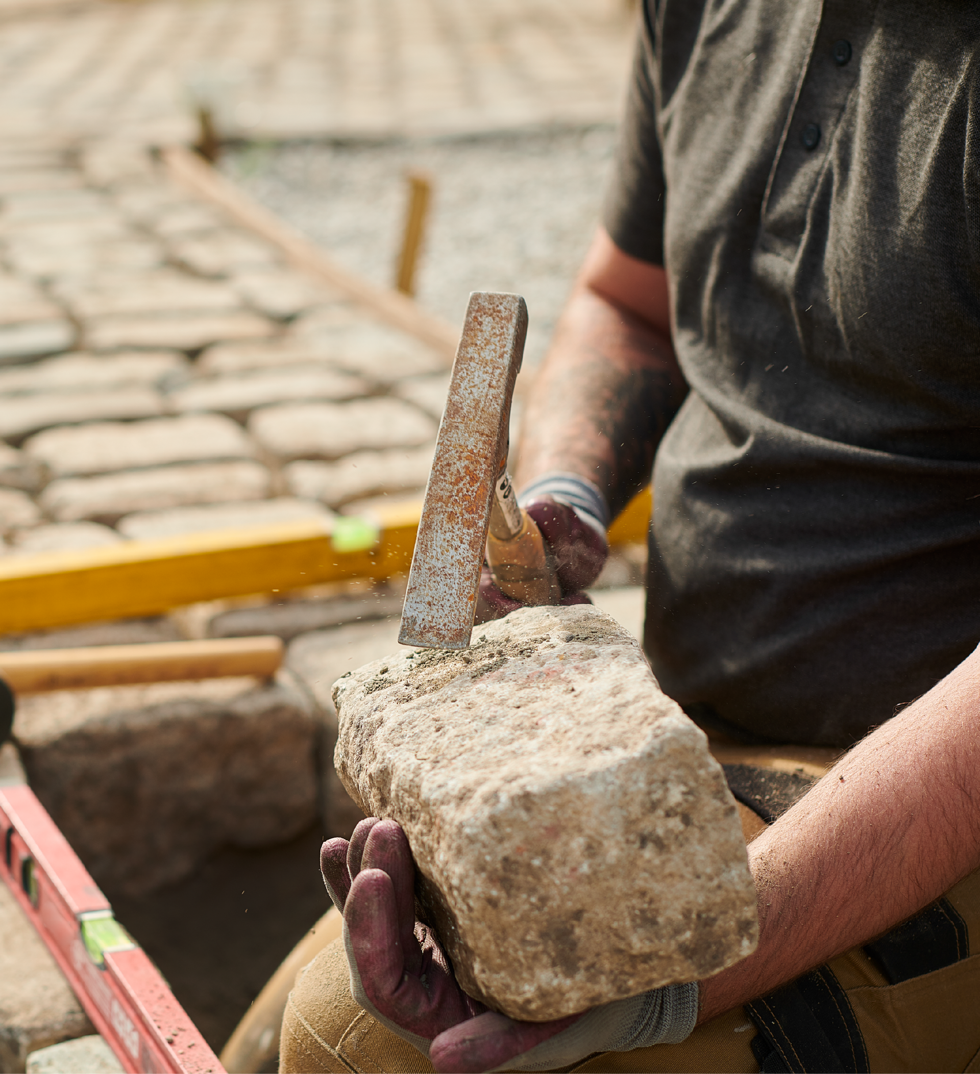 A man wearing a blue hard hat is holding a shovel.