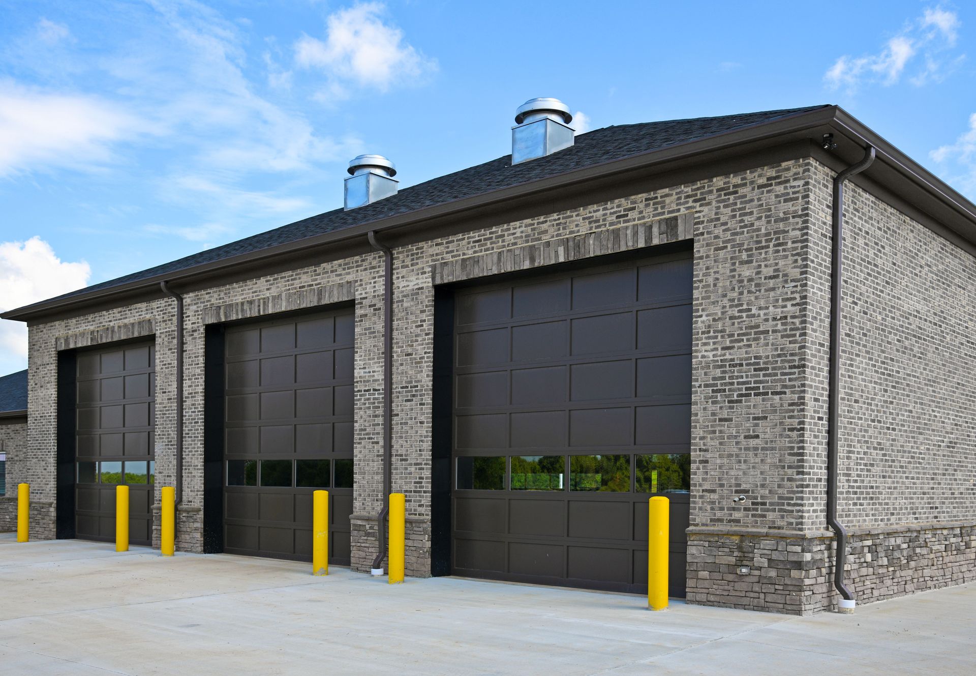 A row of garage doors on a brick building