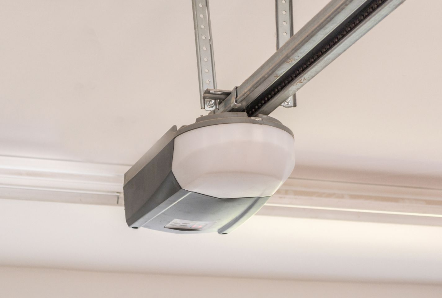 A close up of a garage door opener hanging from the ceiling.
