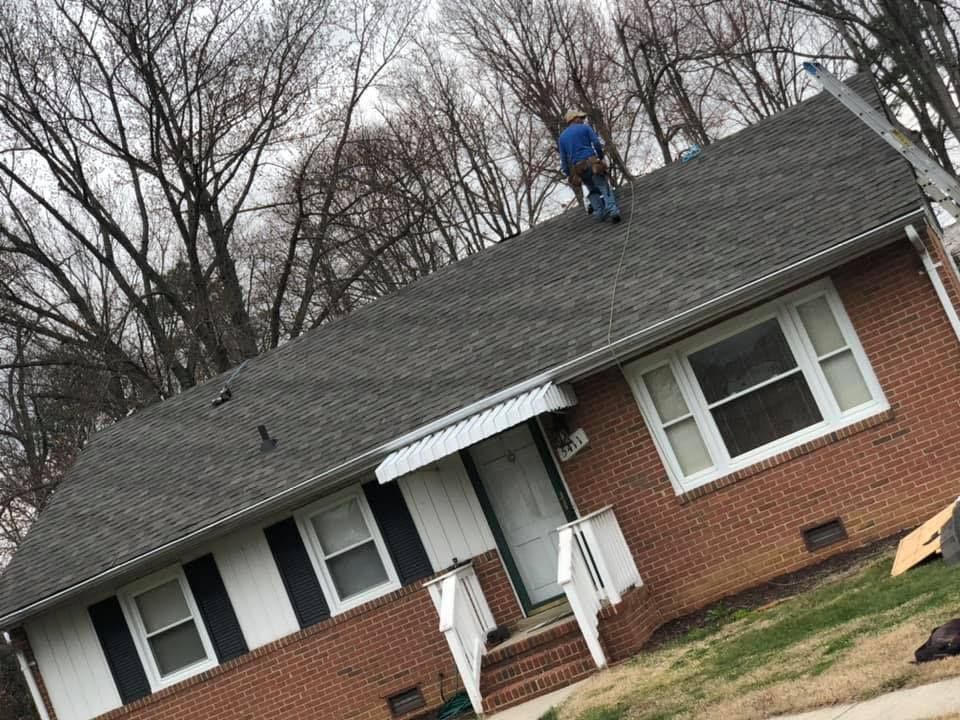 A Man is working on the Roof of a Brick House - Chester, VA - A. Townsley Contracting