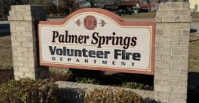 A rectangular sign with Palmer Springs Volunteer Fire Department written on it, held up by two stone pillars.