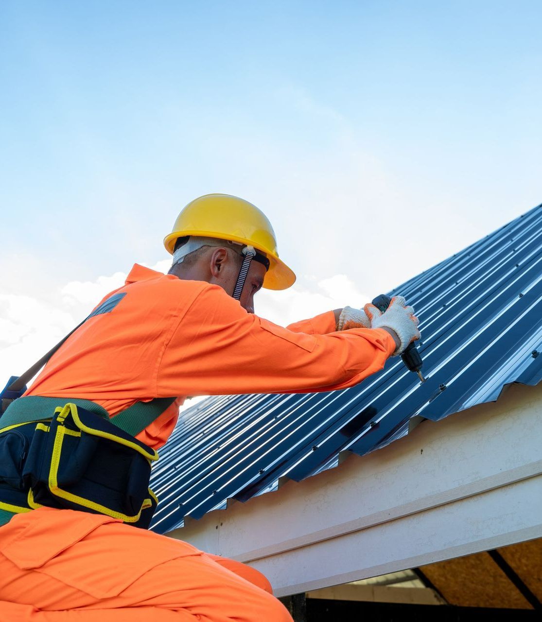 A man in an orange jumpsuit is working on a roof - Heathsville, VA - A Townsley Contracting Roofing