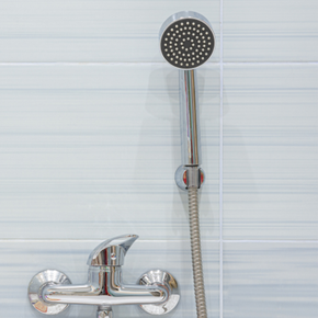 A shower head is attached to a faucet in a bathroom.