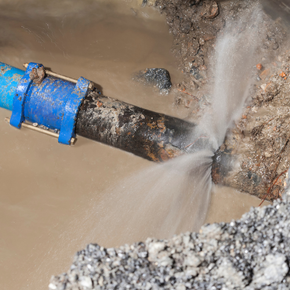 A water pipe is leaking water into the ground.