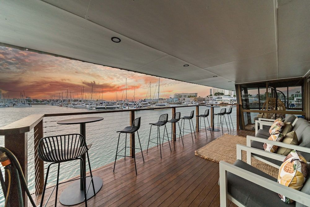 A Large Deck With Tables and Chairs Overlooking the Water — Drawing Works In Townsville City, QLD