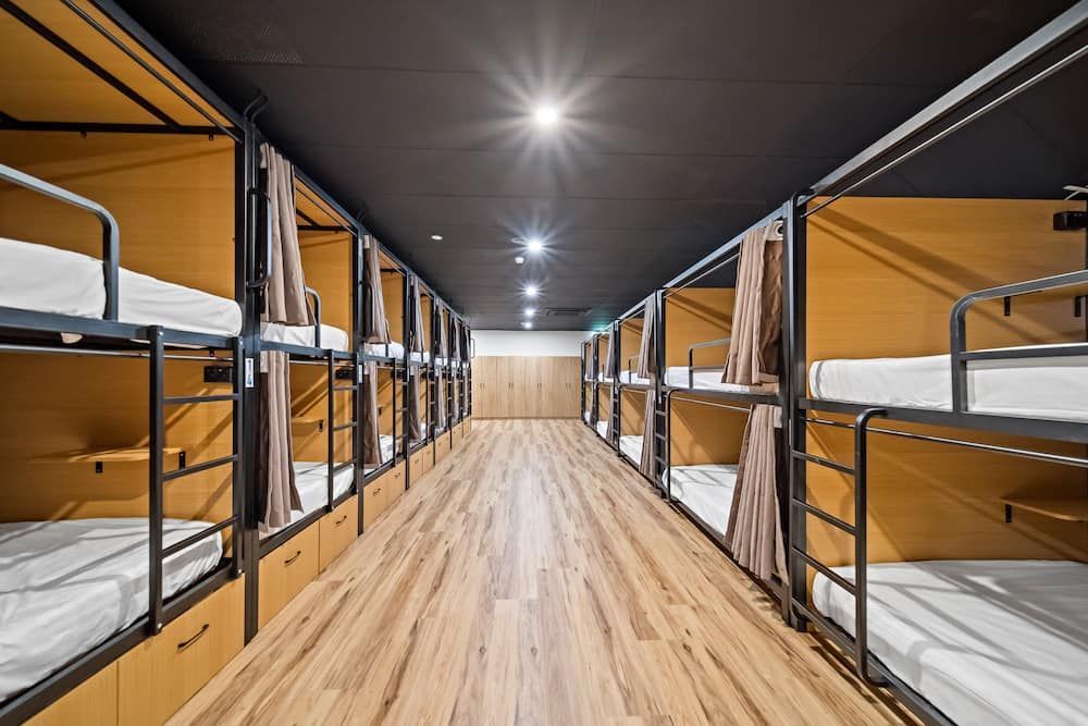 A Row of Bunk Beds in a Dorm Room With Wooden Floors — Drawing Works In Townsville City, QLD