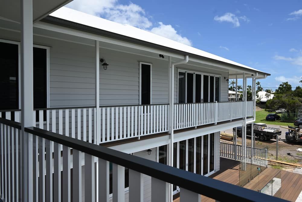 A White House With a Black Door and White Railing — Drawing Works In Townsville City, QLD