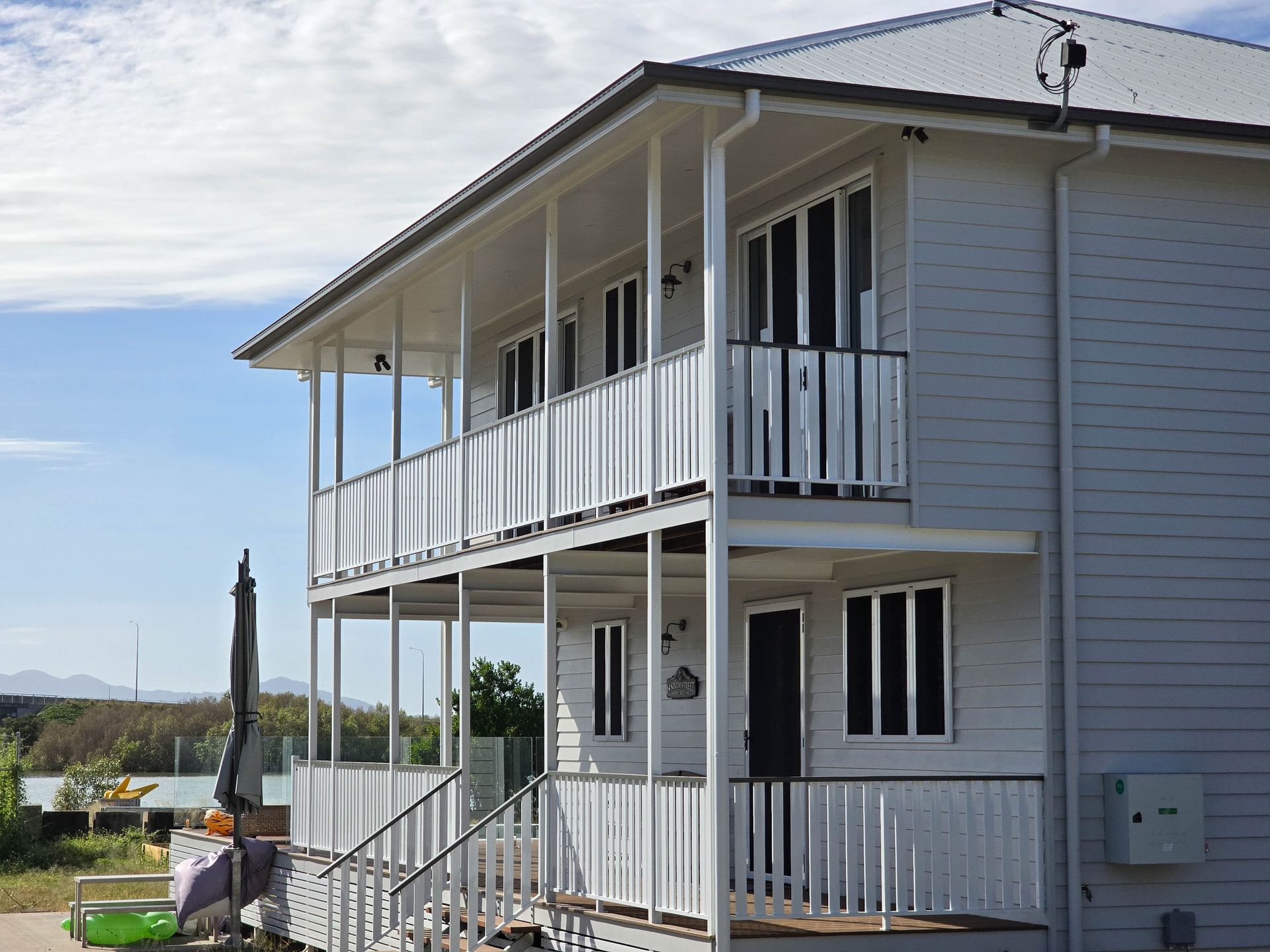 A Small White House is Sitting in the Middle of a Lush Green Field — Drawing Works In Townsville City, QLD