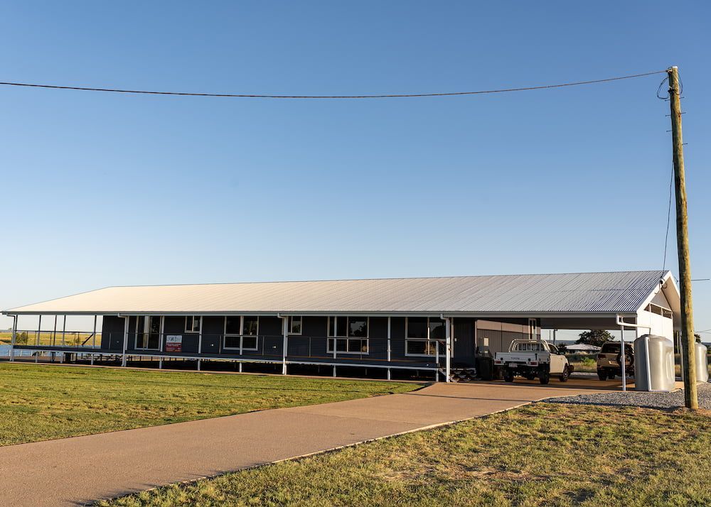 A Large House With a White Roof is Sitting in the Middle of a Grassy Field — Drawing Works In Townsville City, QLD