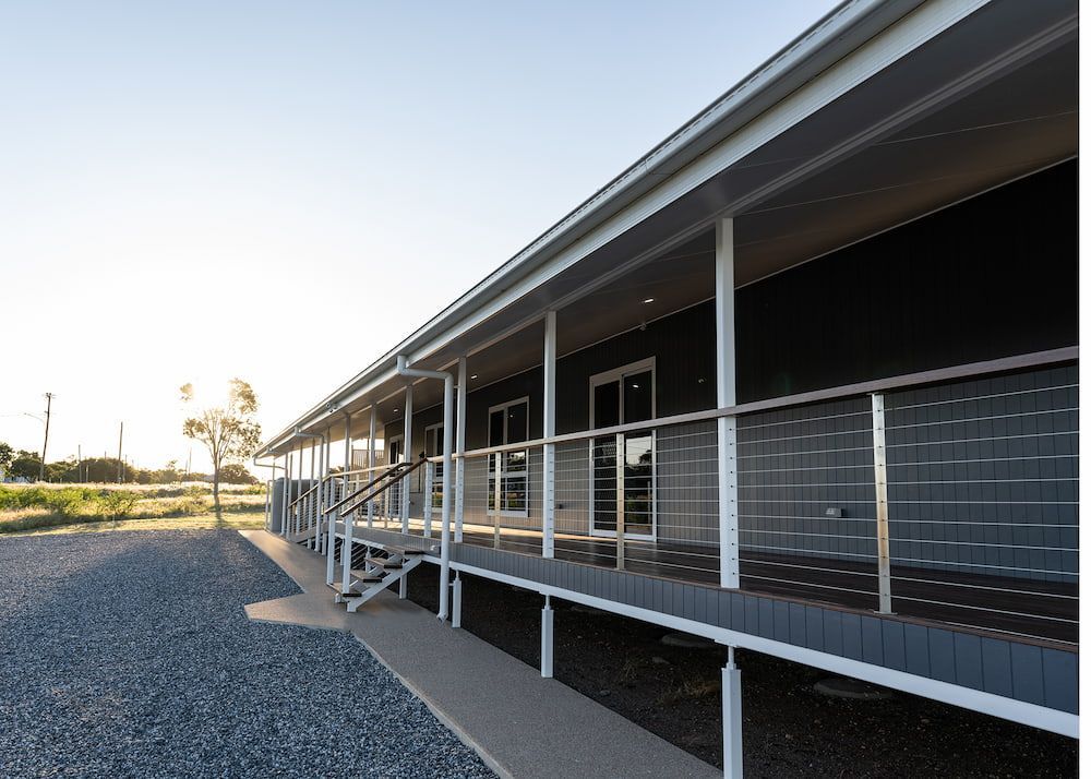 A House is Sitting on the Shore of a Lake at Sunset — Drawing Works In Townsville City, QLD