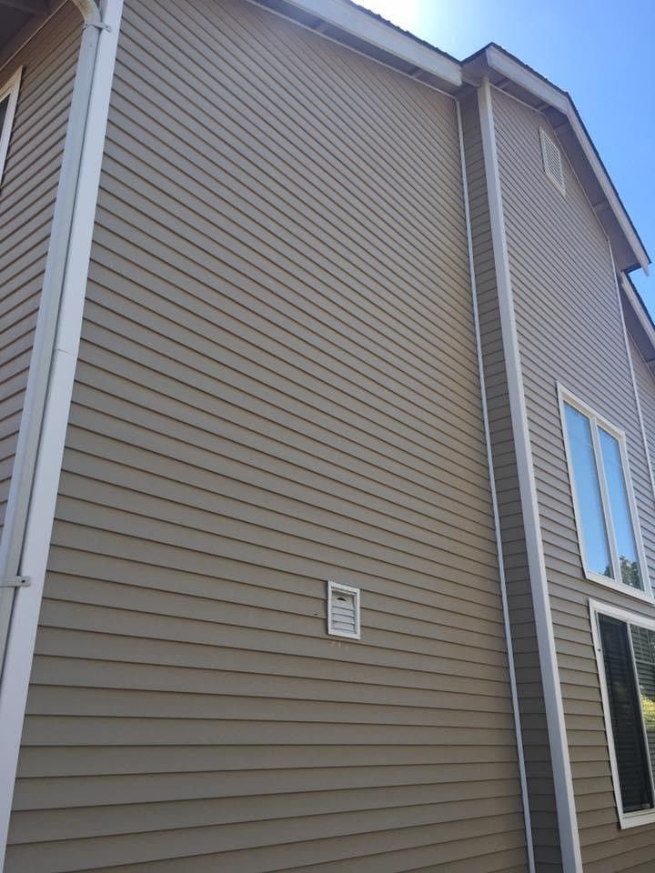 The side of a house with a lot of windows and siding.