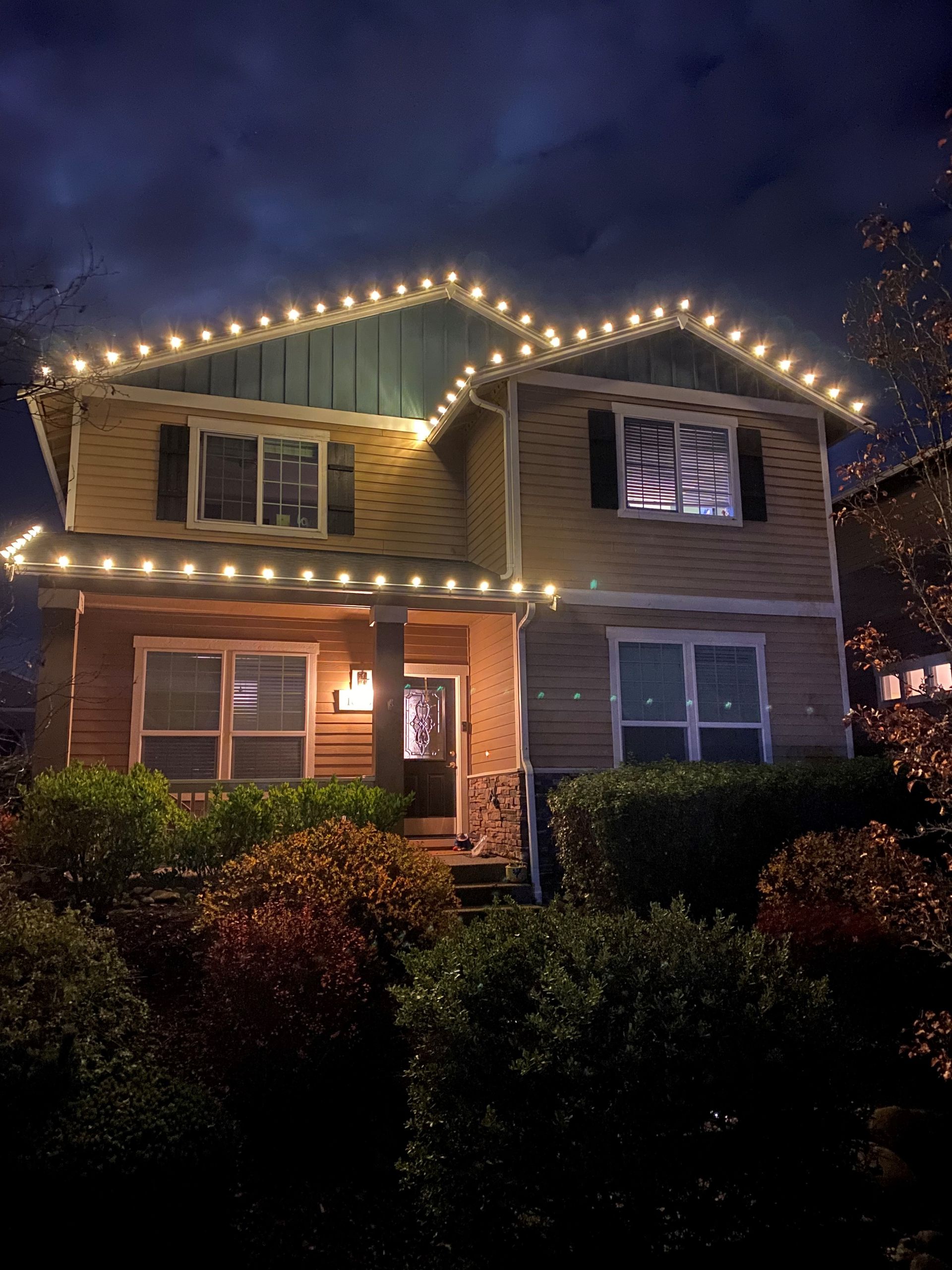 A house with christmas lights on the roof at night