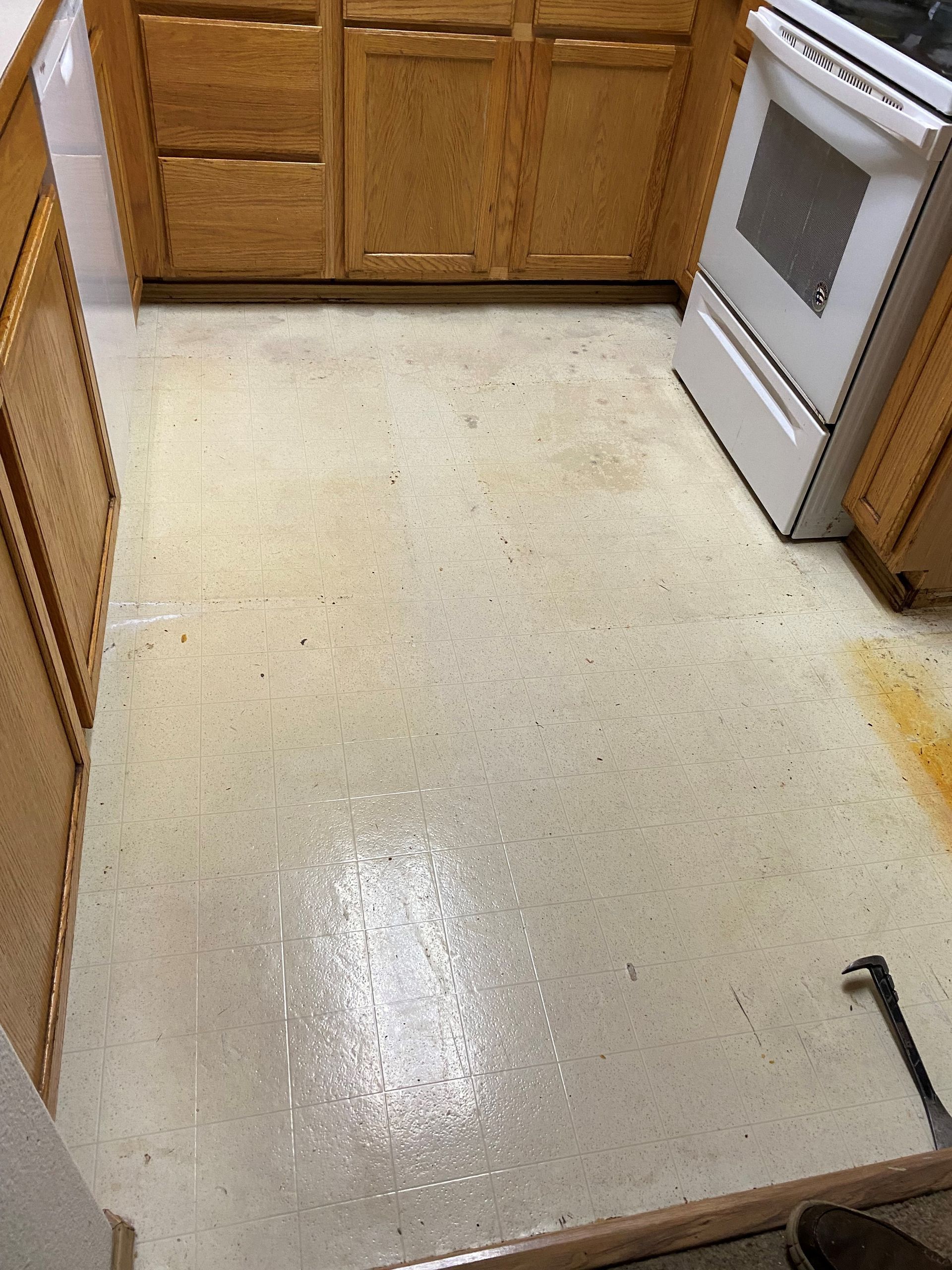A kitchen with wooden cabinets and a white stove.