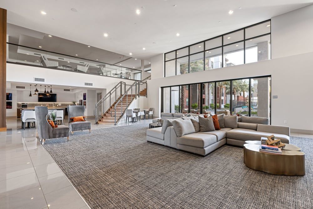 a large room with a couch, chairs, coffee table, and stairs at Marquis at Chandler in Chandler, AZ.
