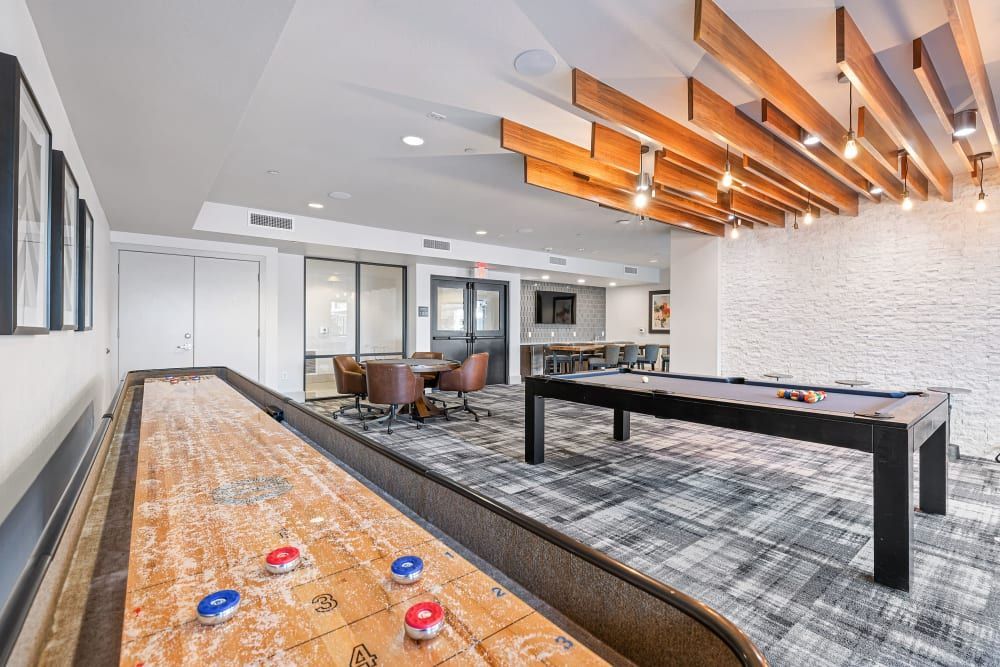 a shuffleboard table in the middle of the room at Marquis at Chandler in Chandler, AZ.