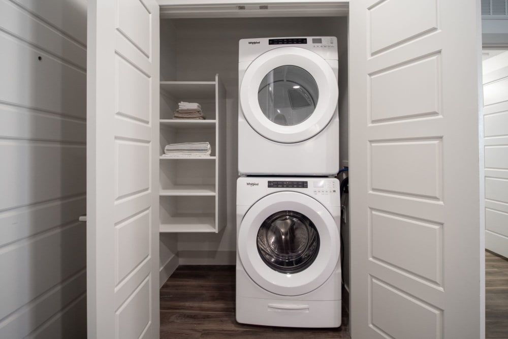 a washer and dryer are stacked on top of each other in a closet at Marquis at Chandler in Chandler, AZ.