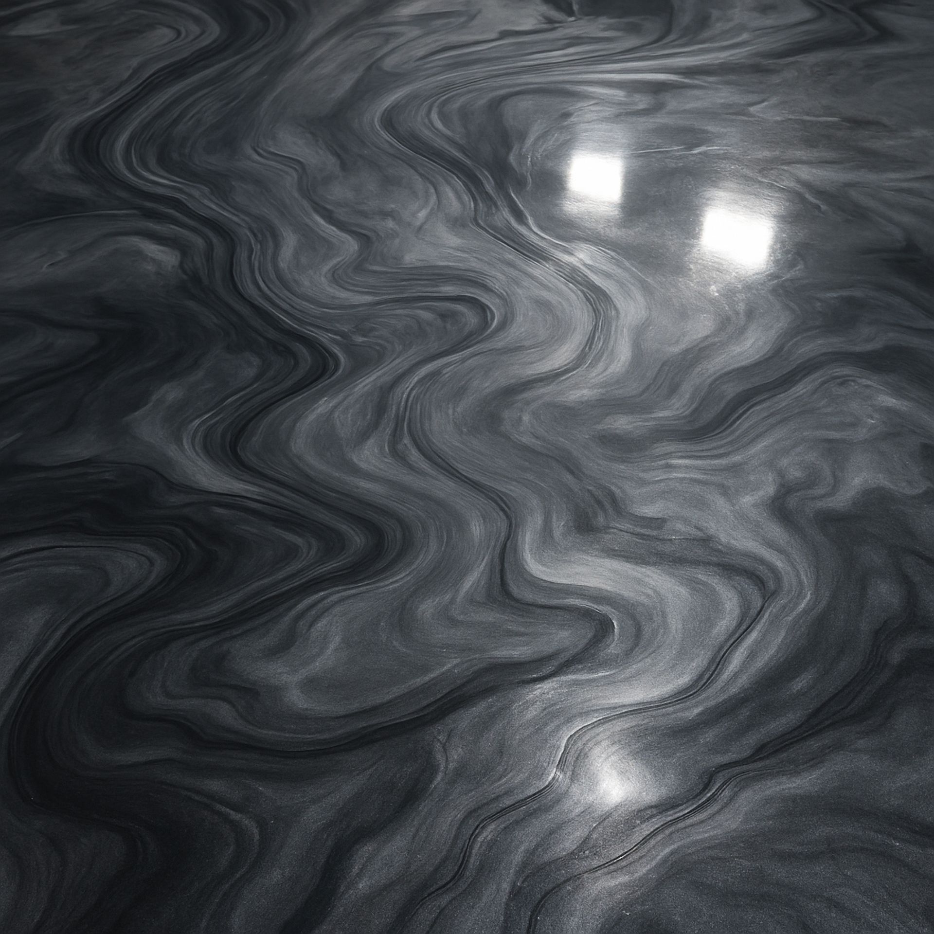 Swirled gray marble surface with bright light reflections