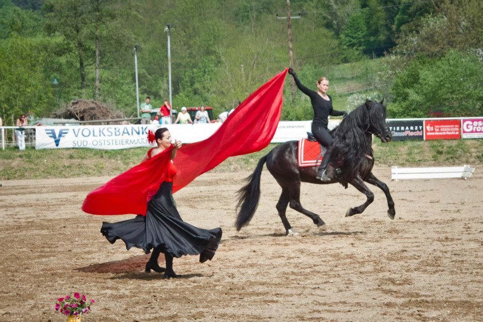 eine Flamencotänzerin mit rotem Tuch und eine Frau auf einem schwarzem Pferd