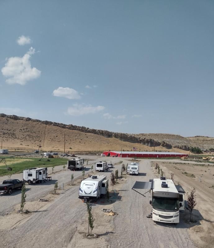 A group of rv 's are parked on a dirt road