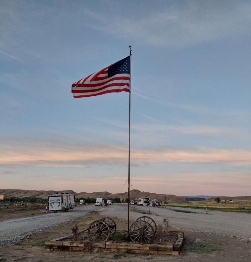 An american flag is flying in the middle of a dirt road