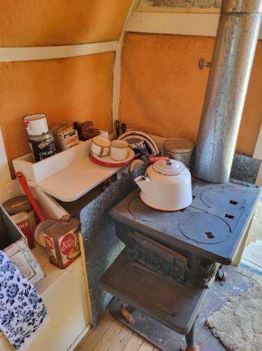 A kitchen with a stove and a kettle on it.