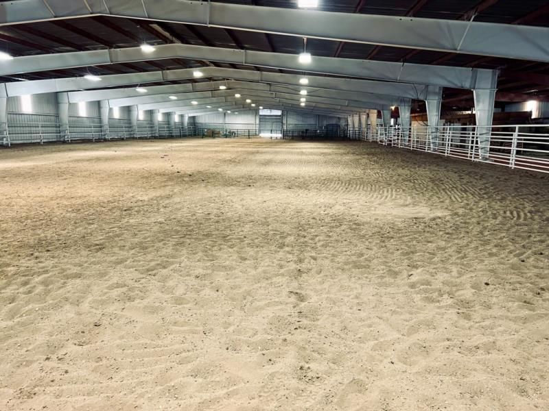A large indoor arena with a lot of sand in it.