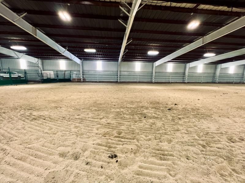 A large indoor arena with a lot of sand in it.